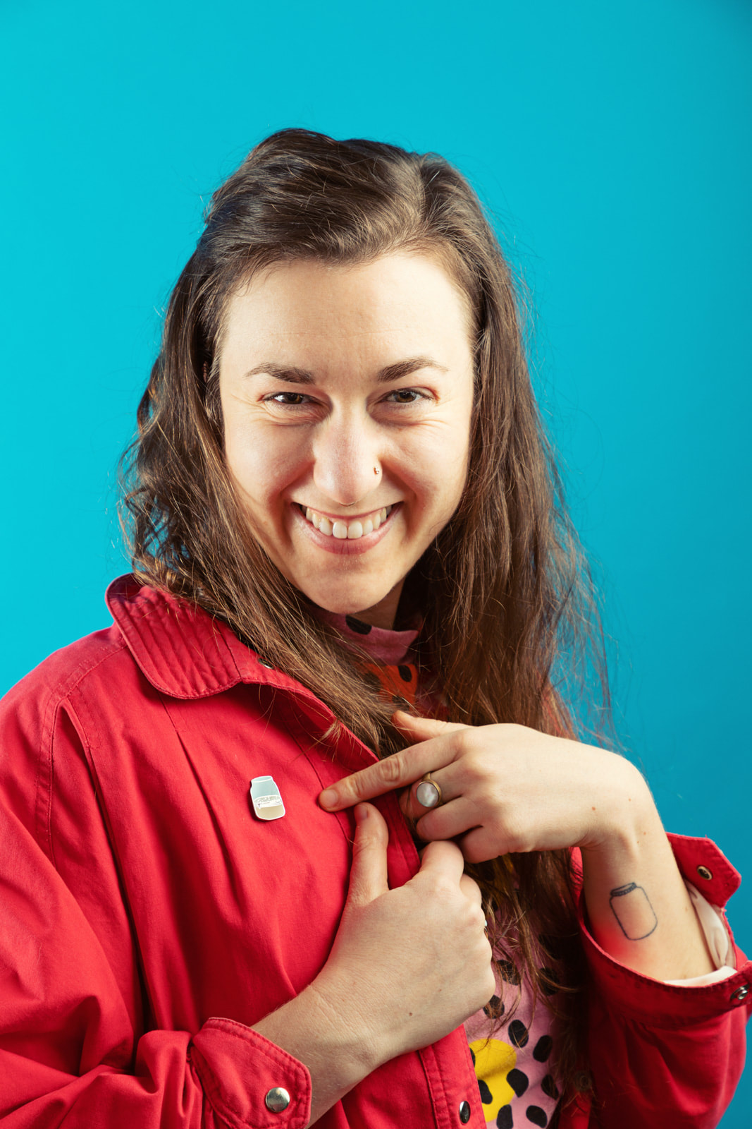 Woman with kombucha enamel pin on red jacket