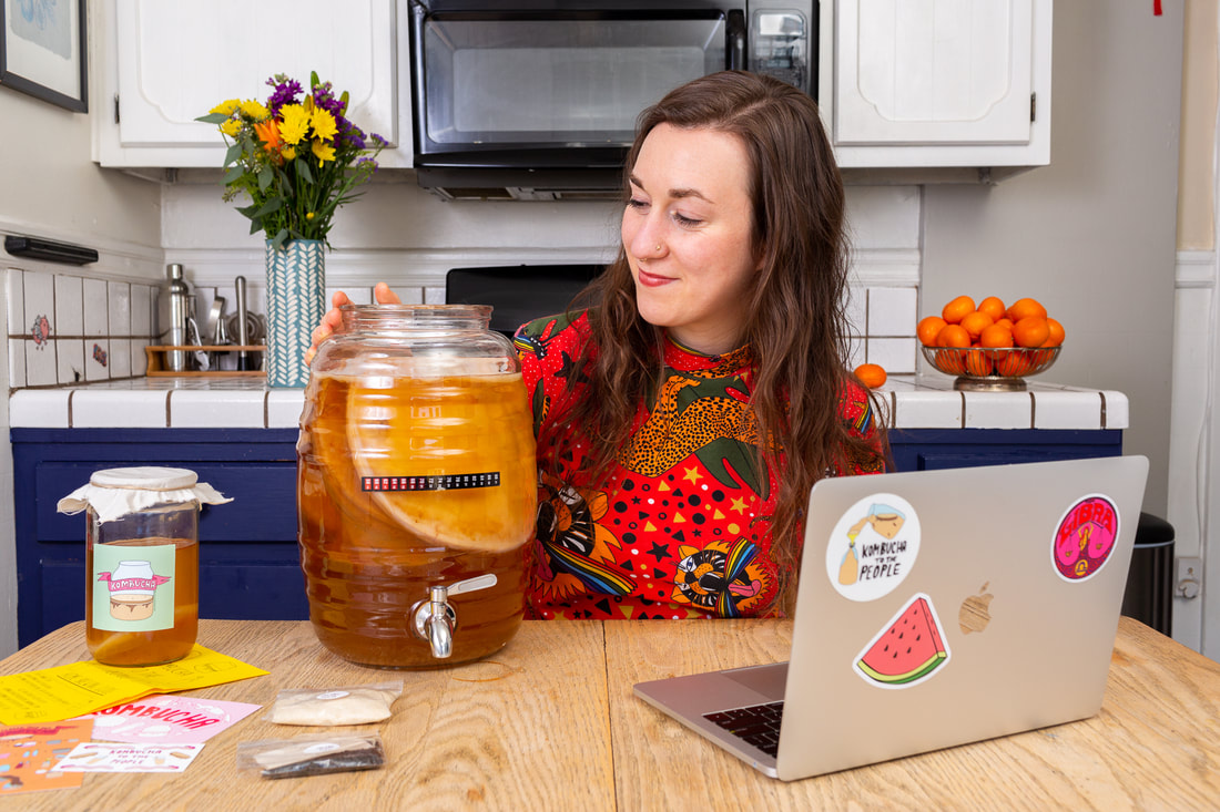 woman with jar of kombucha scoby in kitchen in a virtual kombucha brewing class