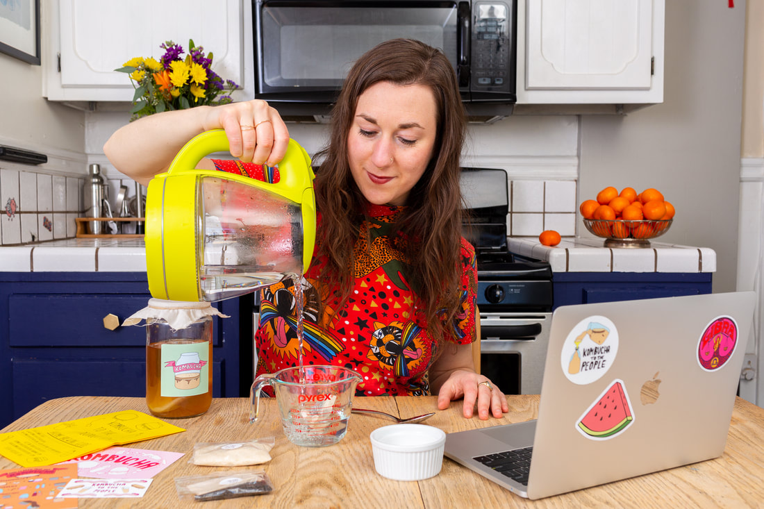 Woman pouring hot water in glass during virtual corporate kombucha brewing class