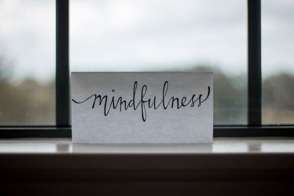 paper that says mindfulness resting in a window